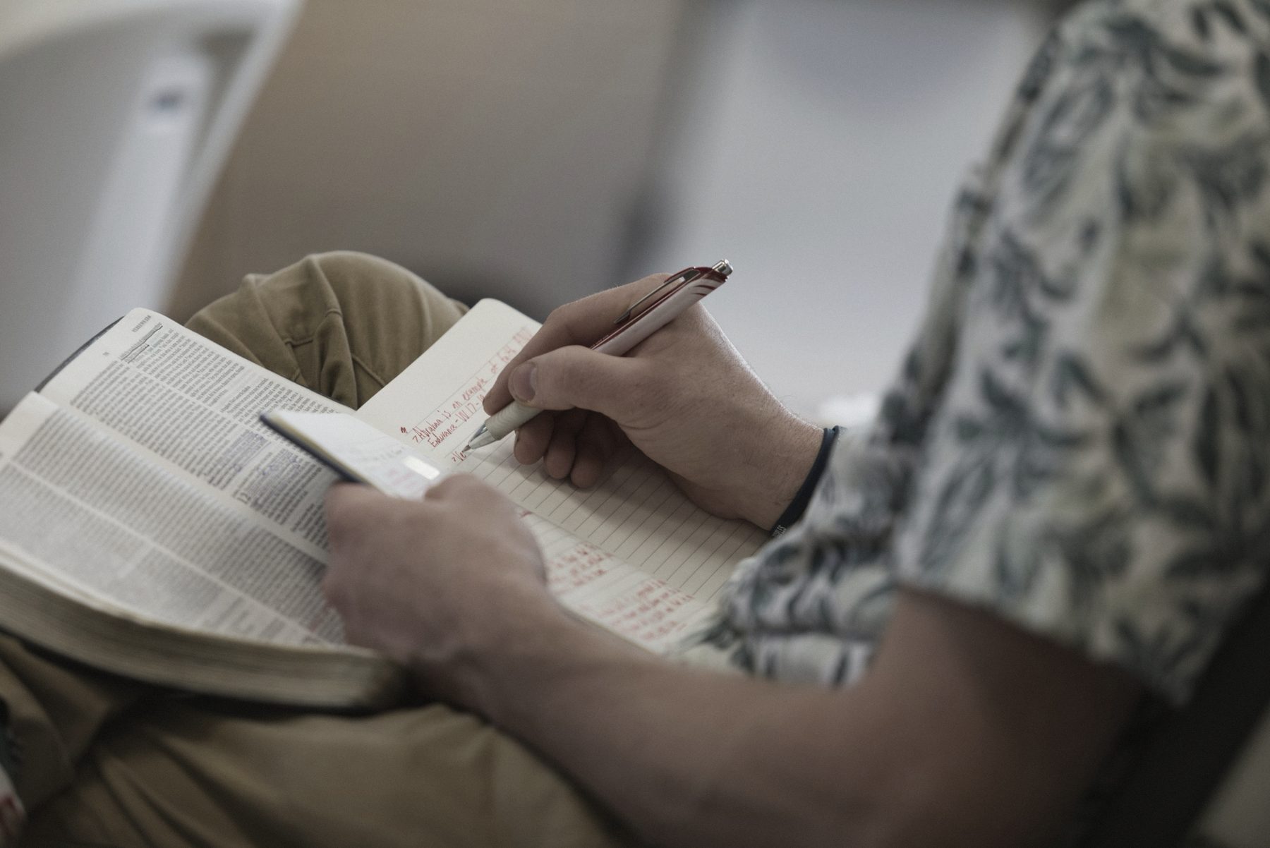 A patient writing questions in a notebook