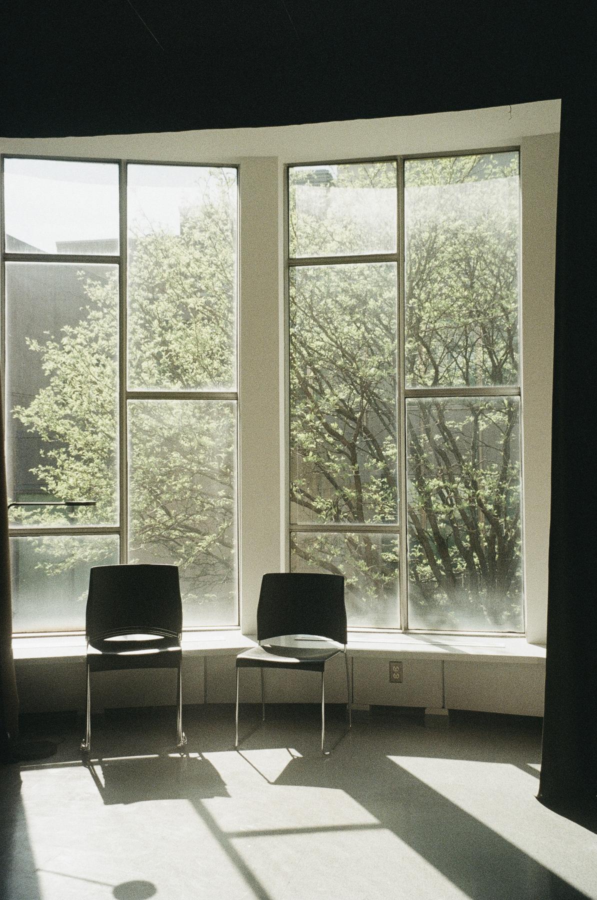 Two chairs by a large window in the waiting room