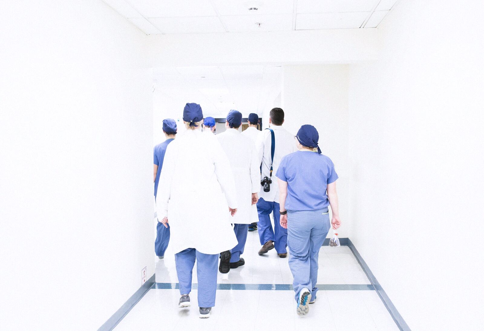 Doctors and nurses walking down a bright corridor