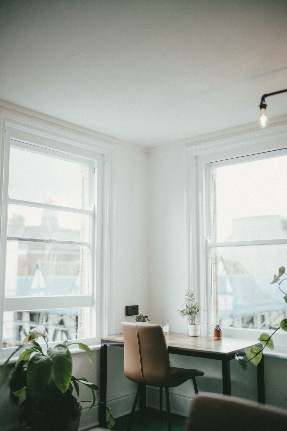 A quiet desk between two bright windows