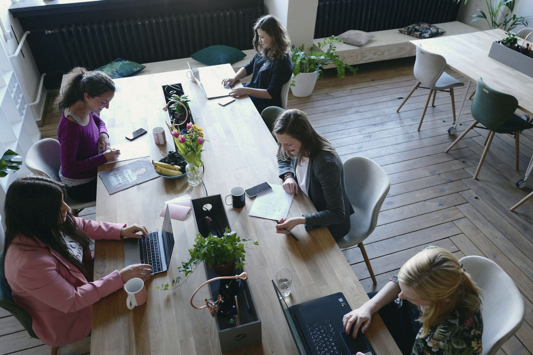 The team working around a long wooden table, seen from above